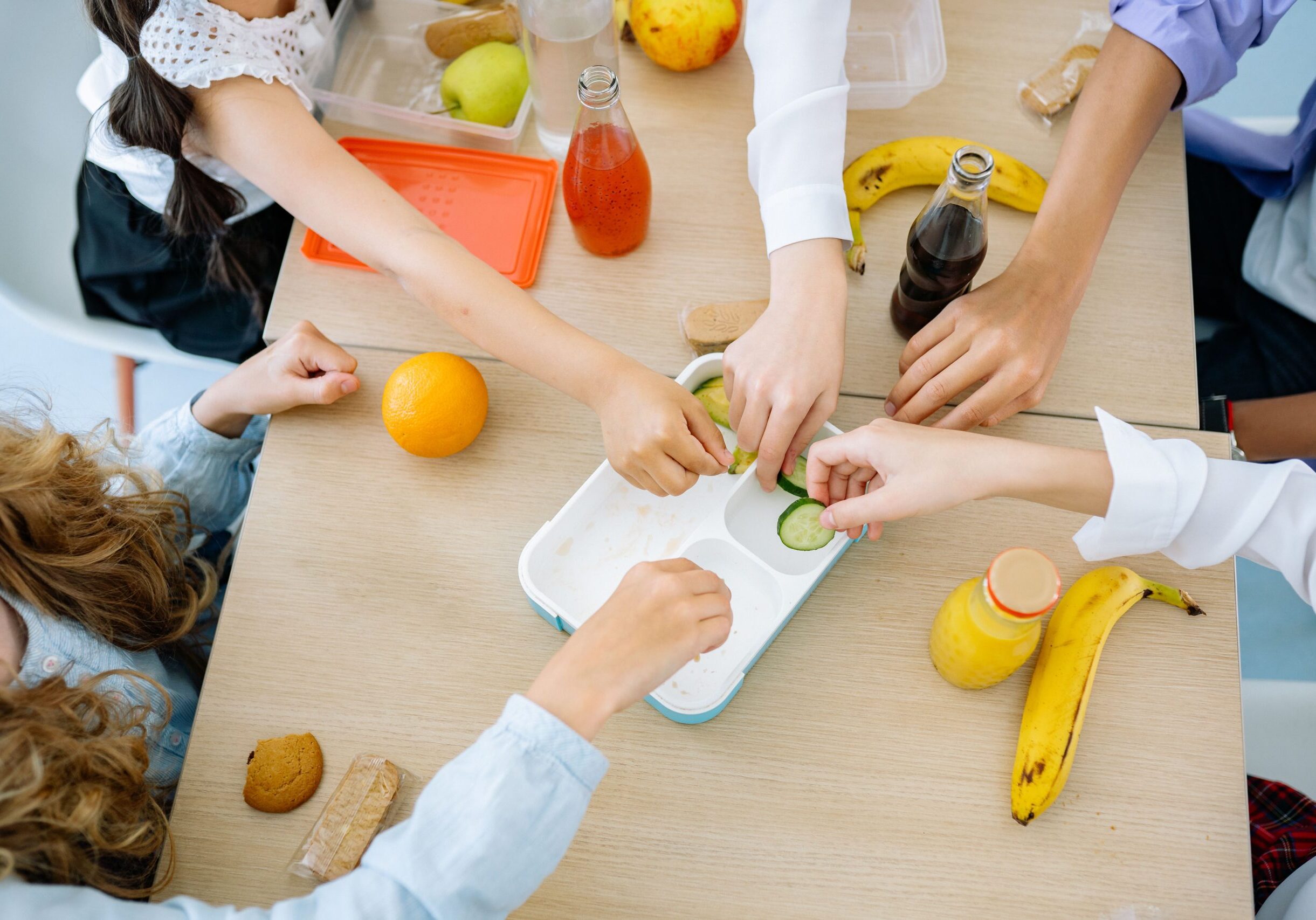 kids' hands preparing colourful fruit and vegetables during Eat the Rainbow workshop)