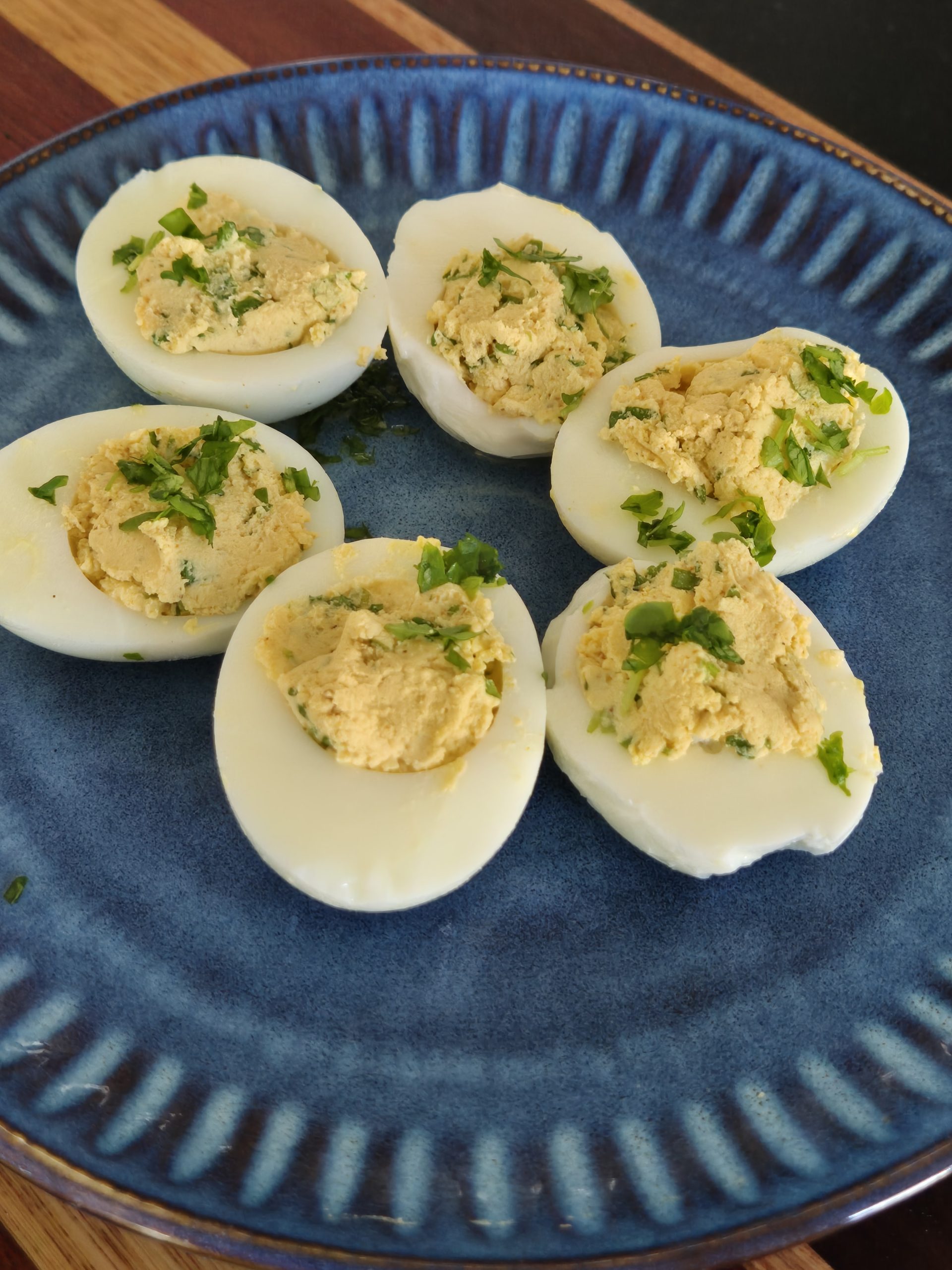 A plate of devilled eggs - boiled eggs halved and thier yolks are mixed with ingredients and spooned back in